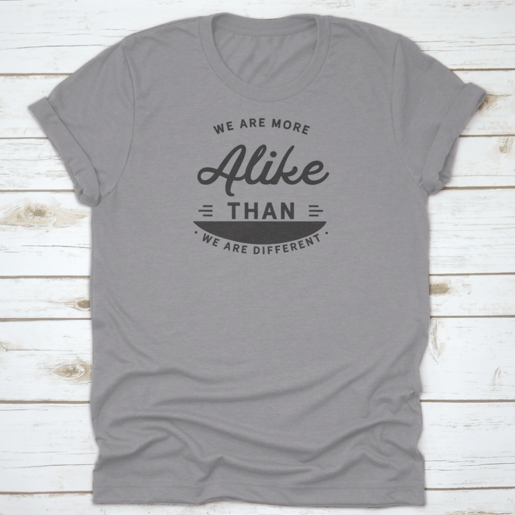 A motivational t-shirt featuring the phrase 'We Are More Alike Than We Are Different', made from soft cotton fabric.