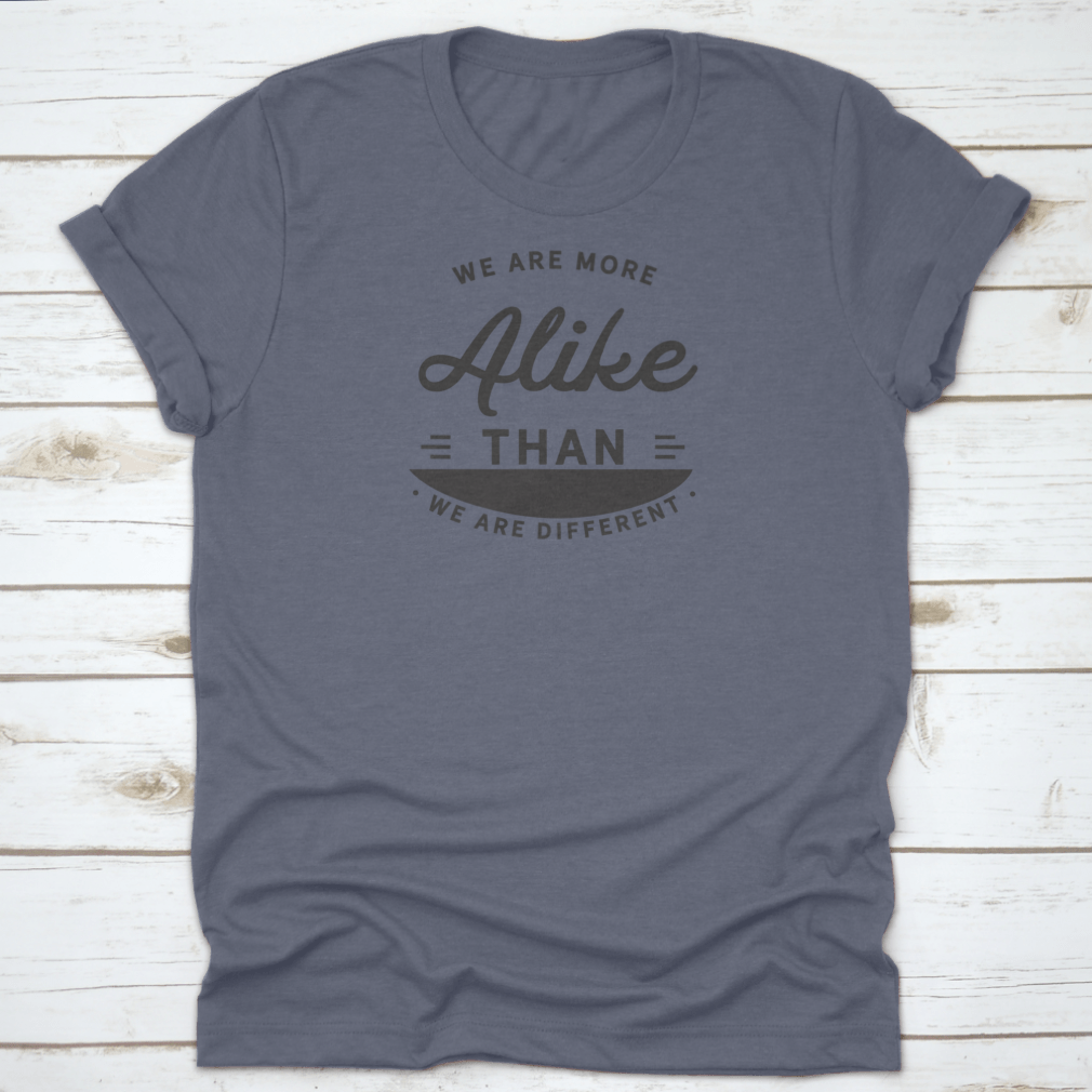 A motivational t-shirt featuring the phrase 'We Are More Alike Than We Are Different', made from soft cotton fabric.