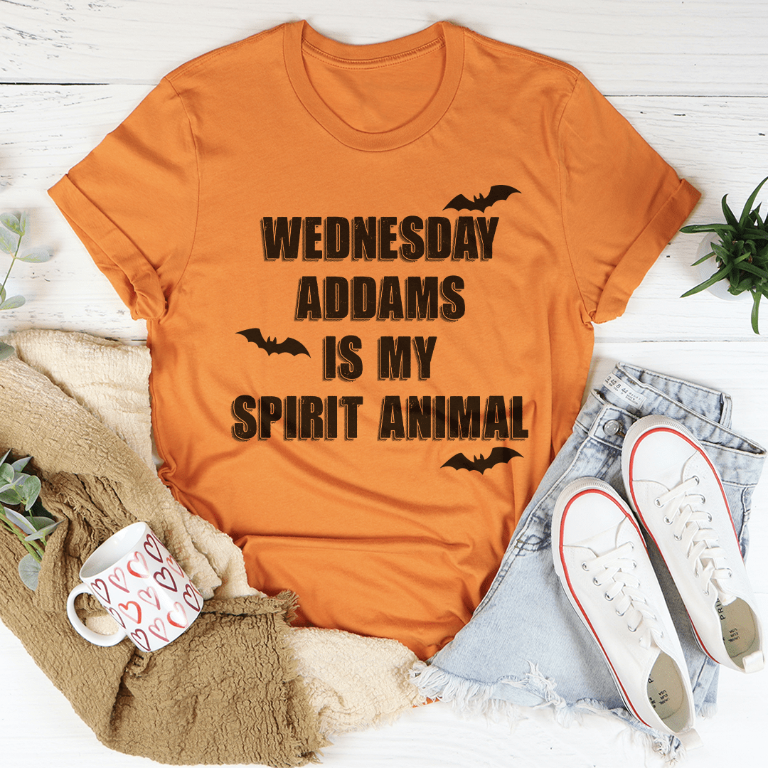 A black tee featuring the phrase 'Wednesday Addams Is My Spirit Animal' in a spooky font, perfect for Halloween.