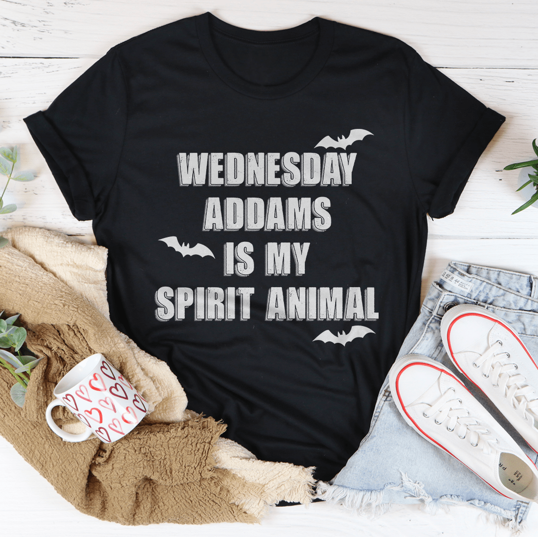 A black tee featuring the phrase 'Wednesday Addams Is My Spirit Animal' in a spooky font, perfect for Halloween.