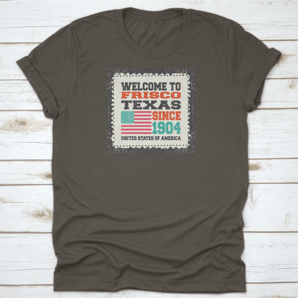 A classic t-shirt featuring the American flag and the text 'Welcome To Frisco, State Texas. Since 1904', made from high-quality cotton.