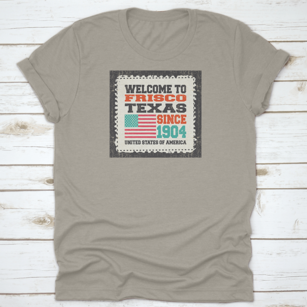 A classic t-shirt featuring the American flag and the text 'Welcome To Frisco, State Texas. Since 1904', made from high-quality cotton.