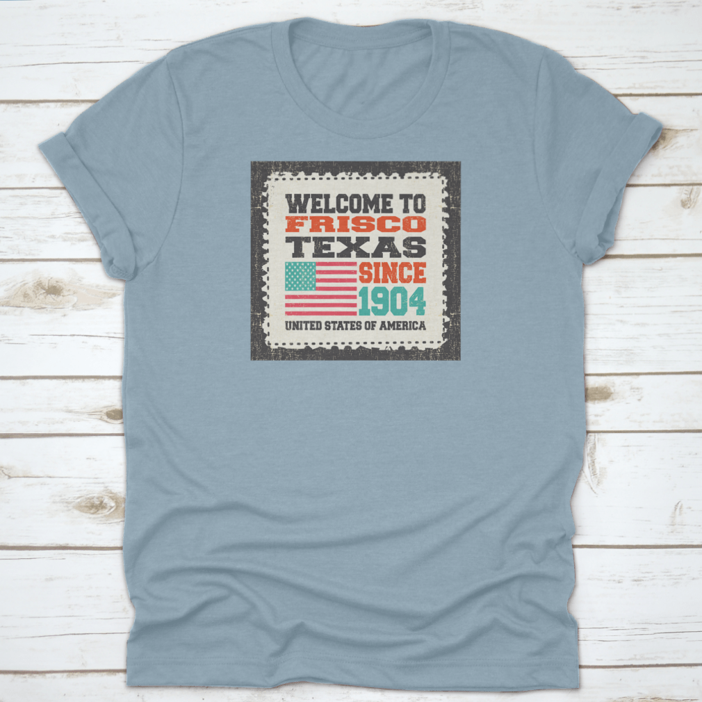 A classic t-shirt featuring the American flag and the text 'Welcome To Frisco, State Texas. Since 1904', made from high-quality cotton.