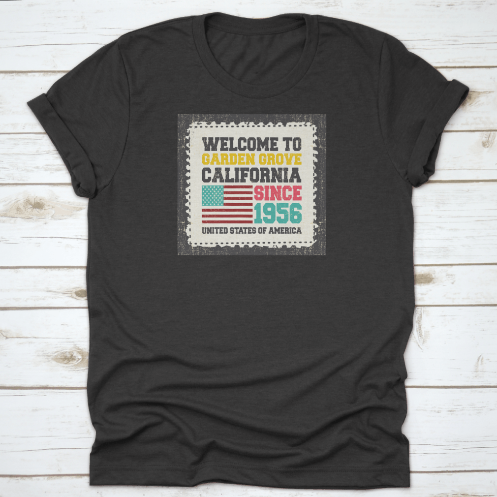 A classic t-shirt featuring the American flag and the text 'Welcome To Garden Grove, California' since 1956, showcasing a vibrant design.