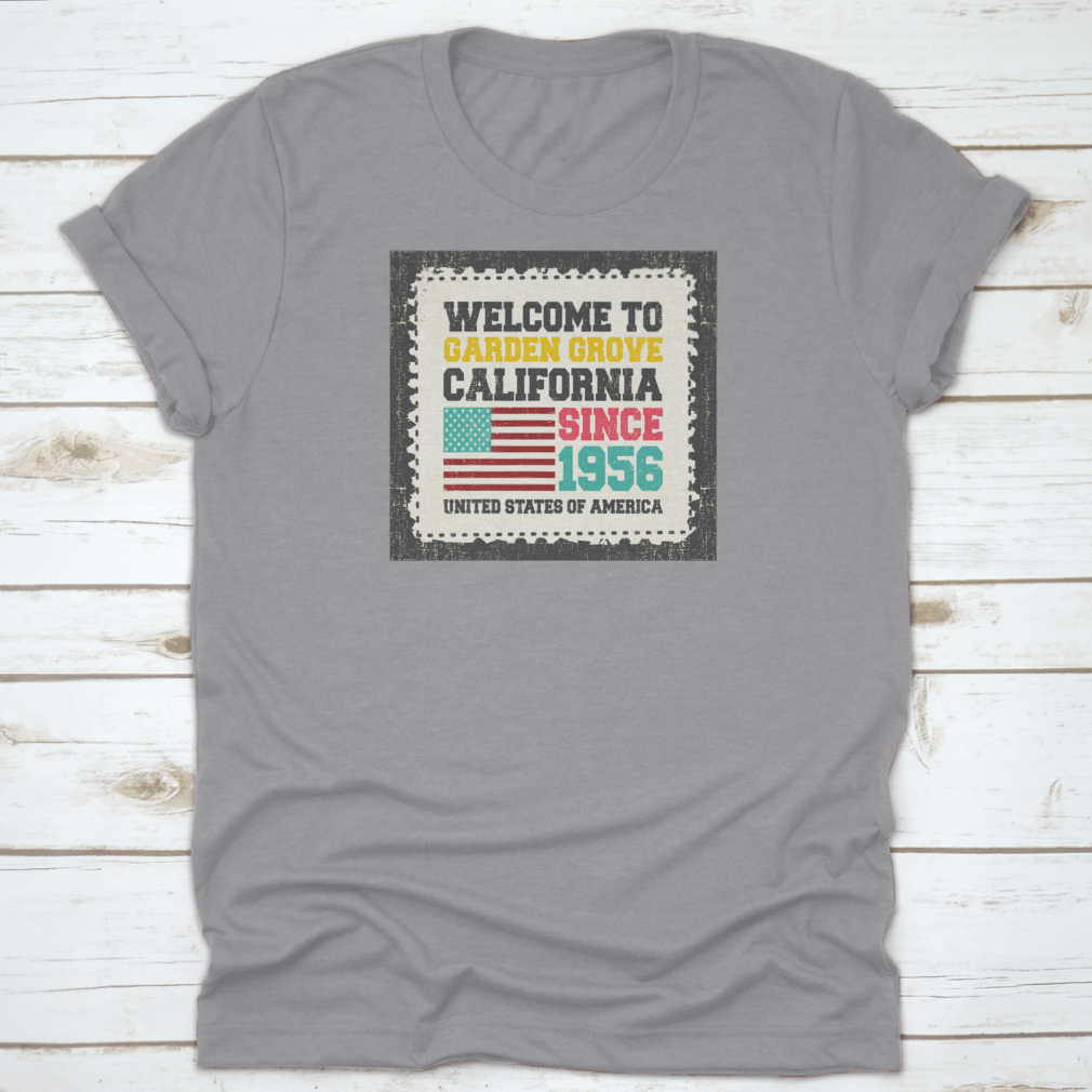 A classic t-shirt featuring the American flag and the text 'Welcome To Garden Grove, California' since 1956, showcasing a vibrant design.