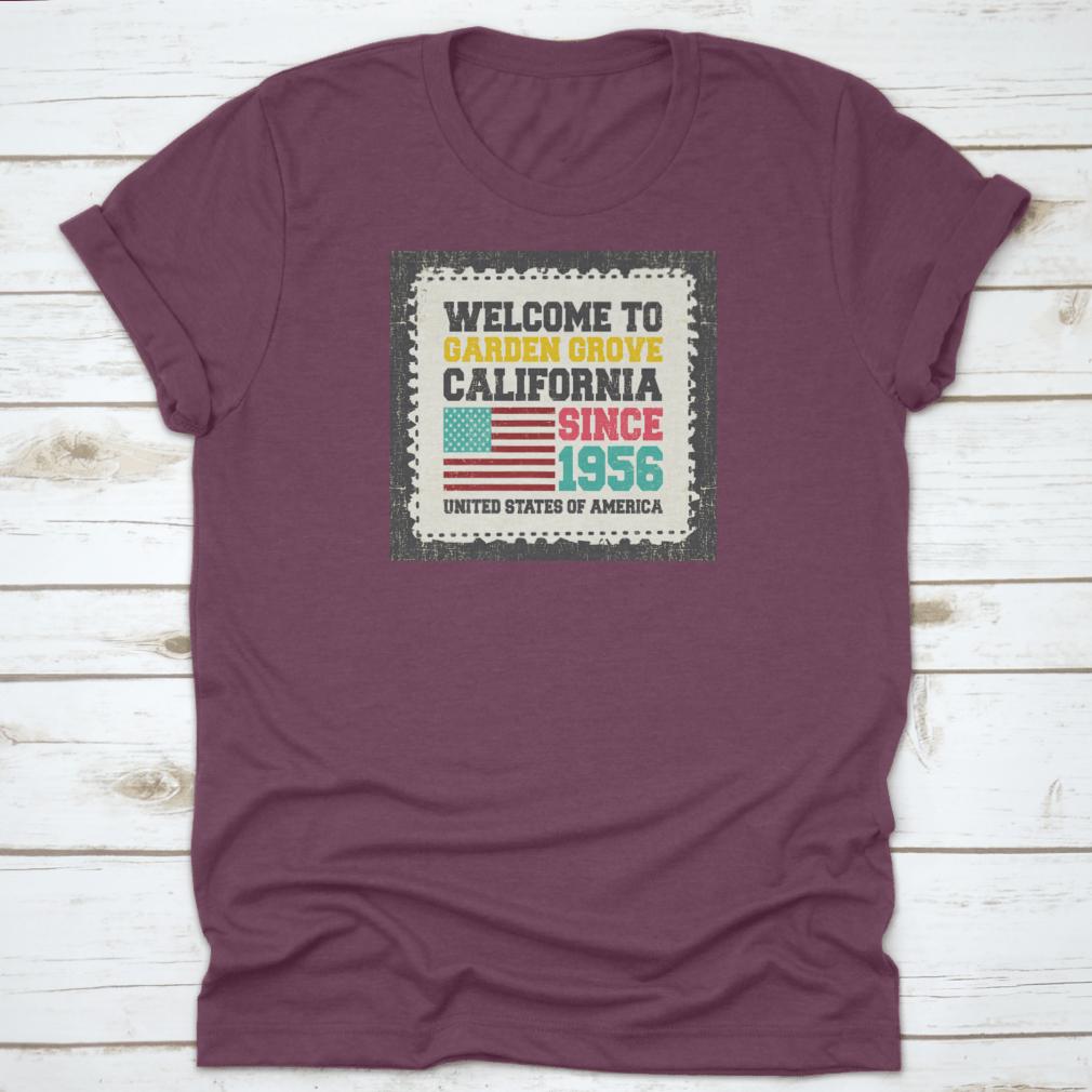 A classic t-shirt featuring the American flag and the text 'Welcome To Garden Grove, California' since 1956, showcasing a vibrant design.