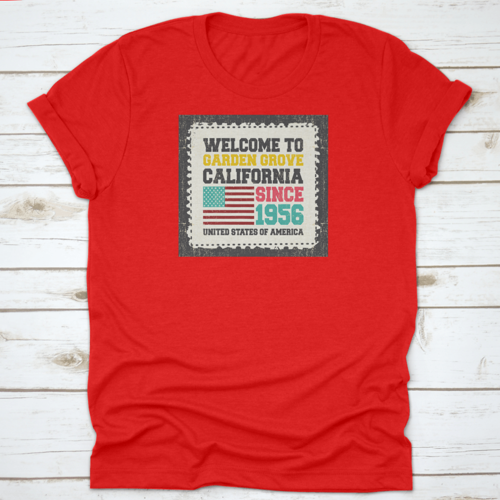 A classic t-shirt featuring the American flag and the text 'Welcome To Garden Grove, California' since 1956, showcasing a vibrant design.