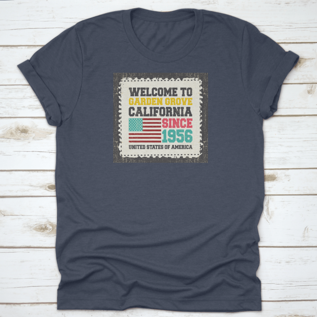 A classic t-shirt featuring the American flag and the text 'Welcome To Garden Grove, California' since 1956, showcasing a vibrant design.