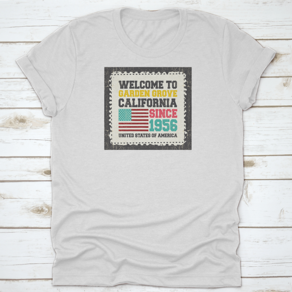 A classic t-shirt featuring the American flag and the text 'Welcome To Garden Grove, California' since 1956, showcasing a vibrant design.