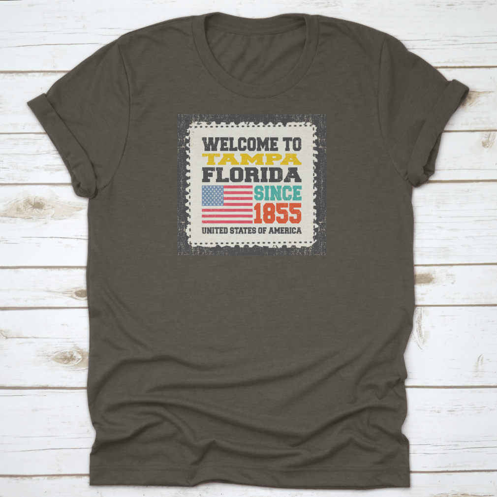 A classic cotton t-shirt featuring the phrase 'Welcome To Tampa, State Florida. Since 1855' with an American flag design.