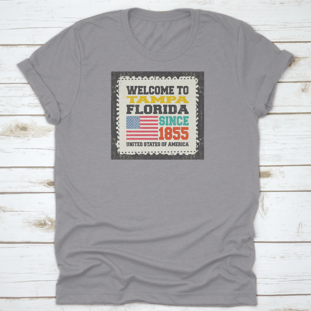 A classic cotton t-shirt featuring the phrase 'Welcome To Tampa, State Florida. Since 1855' with an American flag design.