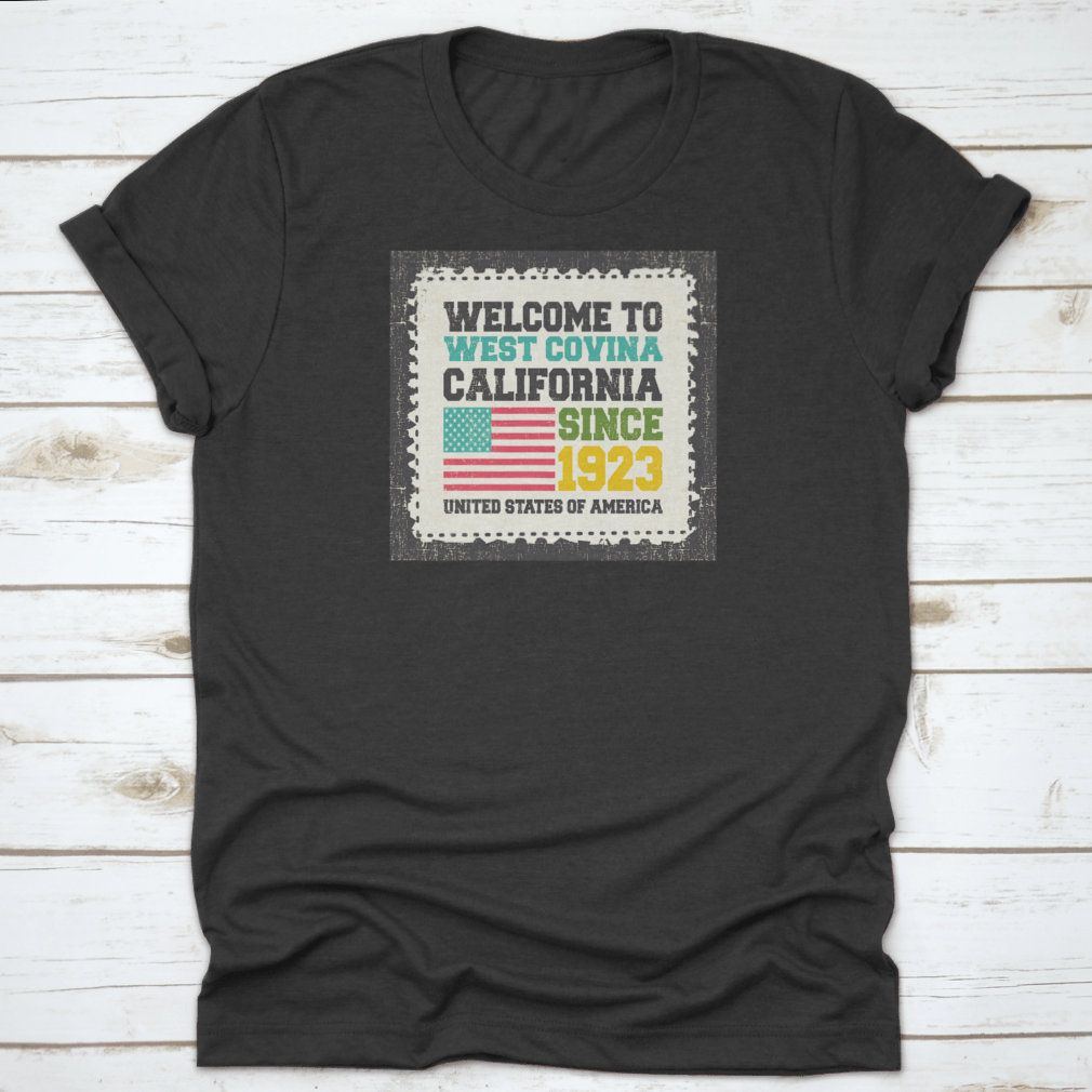 A classic t-shirt featuring the American flag and the text 'Welcome To West Covina State California Since 1923', showcasing pride for the city.