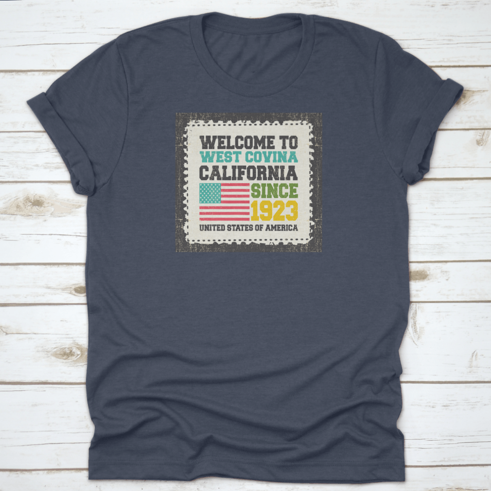 A classic t-shirt featuring the American flag and the text 'Welcome To West Covina State California Since 1923', showcasing pride for the city.