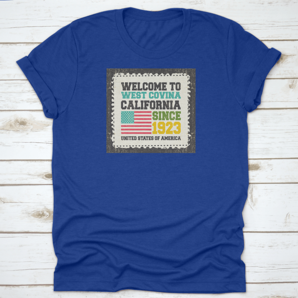 A classic t-shirt featuring the American flag and the text 'Welcome To West Covina State California Since 1923', showcasing pride for the city.