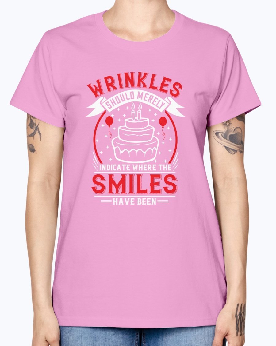 A stylish women's t-shirt featuring the quote 'Wrinkles should merely indicate where the smiles have been' in a cheerful font, perfect for birthday celebrations.