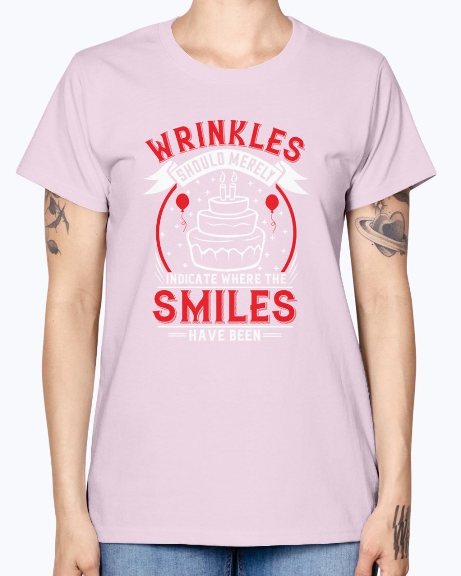 A stylish women's t-shirt featuring the quote 'Wrinkles should merely indicate where the smiles have been' in a cheerful font, perfect for birthday celebrations.