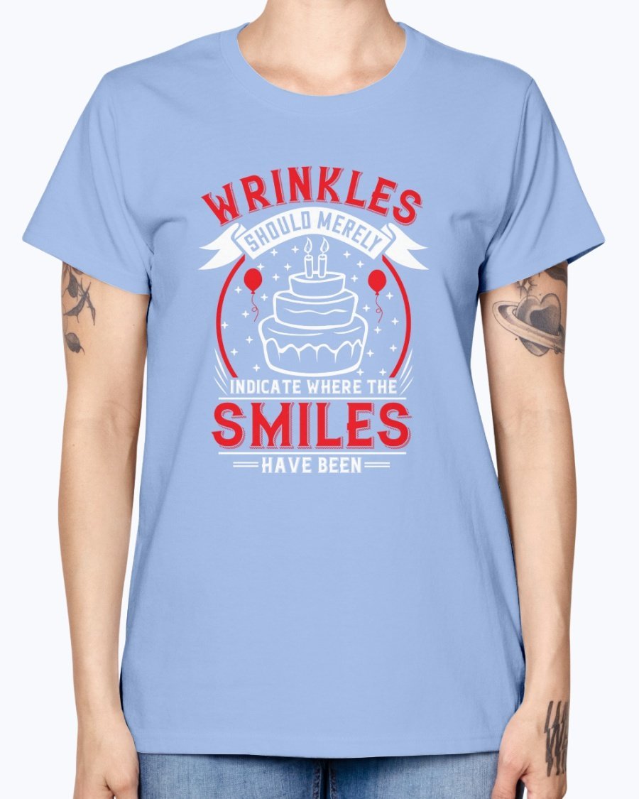 A stylish women's t-shirt featuring the quote 'Wrinkles should merely indicate where the smiles have been' in a cheerful font, perfect for birthday celebrations.
