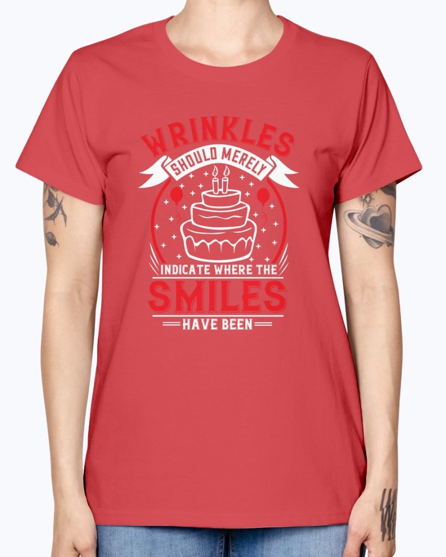A stylish women's t-shirt featuring the quote 'Wrinkles should merely indicate where the smiles have been' in a cheerful font, perfect for birthday celebrations.