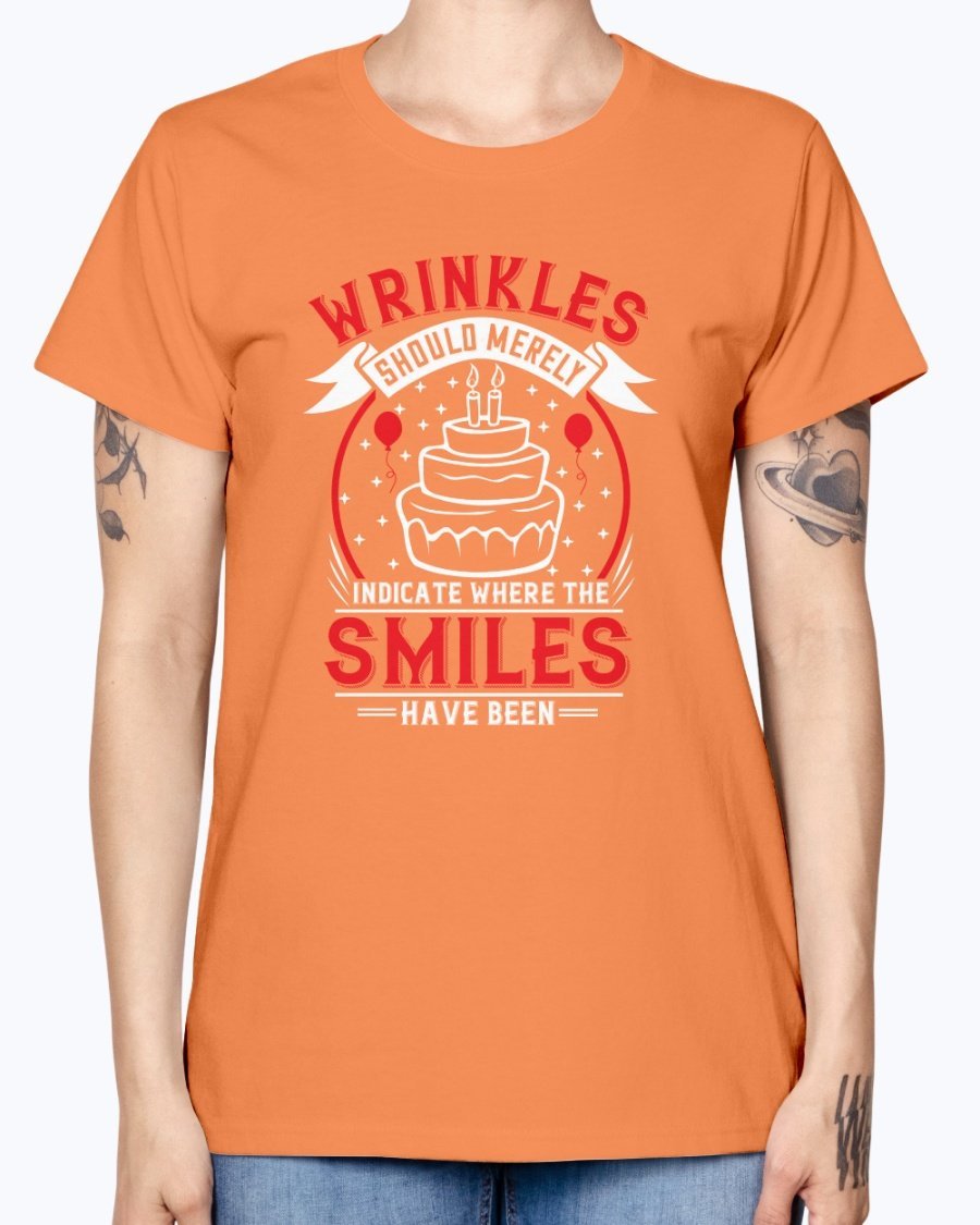 A stylish women's t-shirt featuring the quote 'Wrinkles should merely indicate where the smiles have been' in a cheerful font, perfect for birthday celebrations.