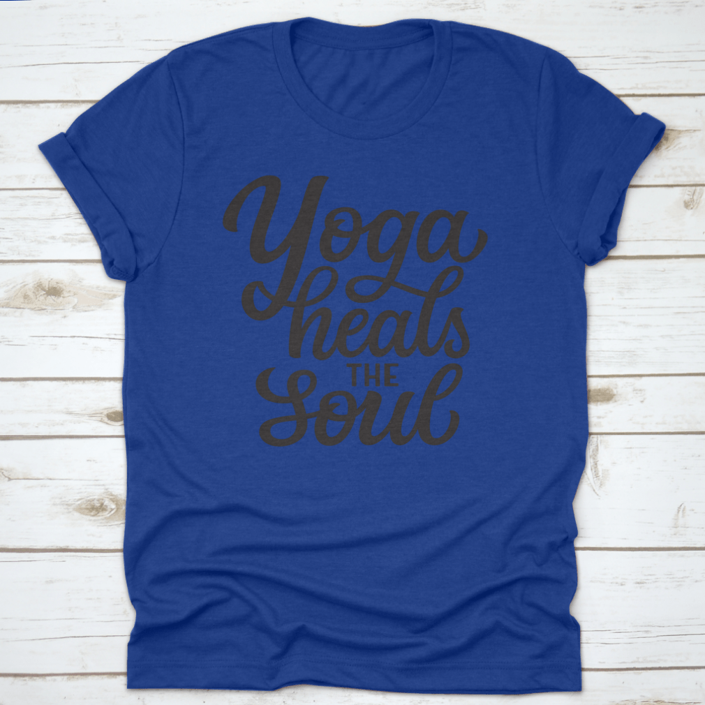 A hand-drawn quote 'Yoga Heals The Soul' printed on a white cotton t-shirt, showcasing a stylish and inspirational design.