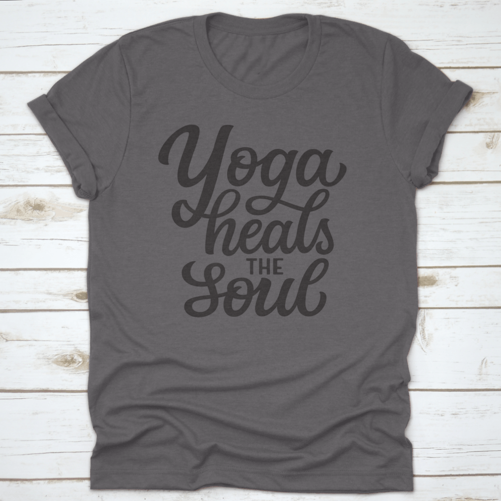 A hand-drawn quote 'Yoga Heals The Soul' printed on a white cotton t-shirt, showcasing a stylish and inspirational design.