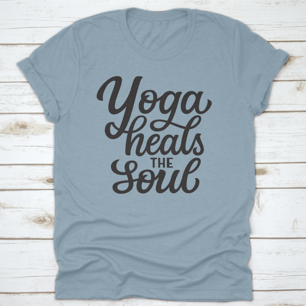 A hand-drawn quote 'Yoga Heals The Soul' printed on a white cotton t-shirt, showcasing a stylish and inspirational design.