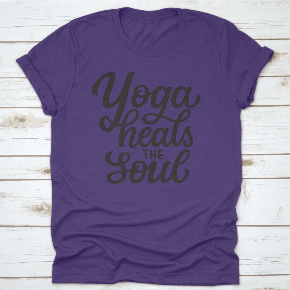 A hand-drawn quote 'Yoga Heals The Soul' printed on a white cotton t-shirt, showcasing a stylish and inspirational design.