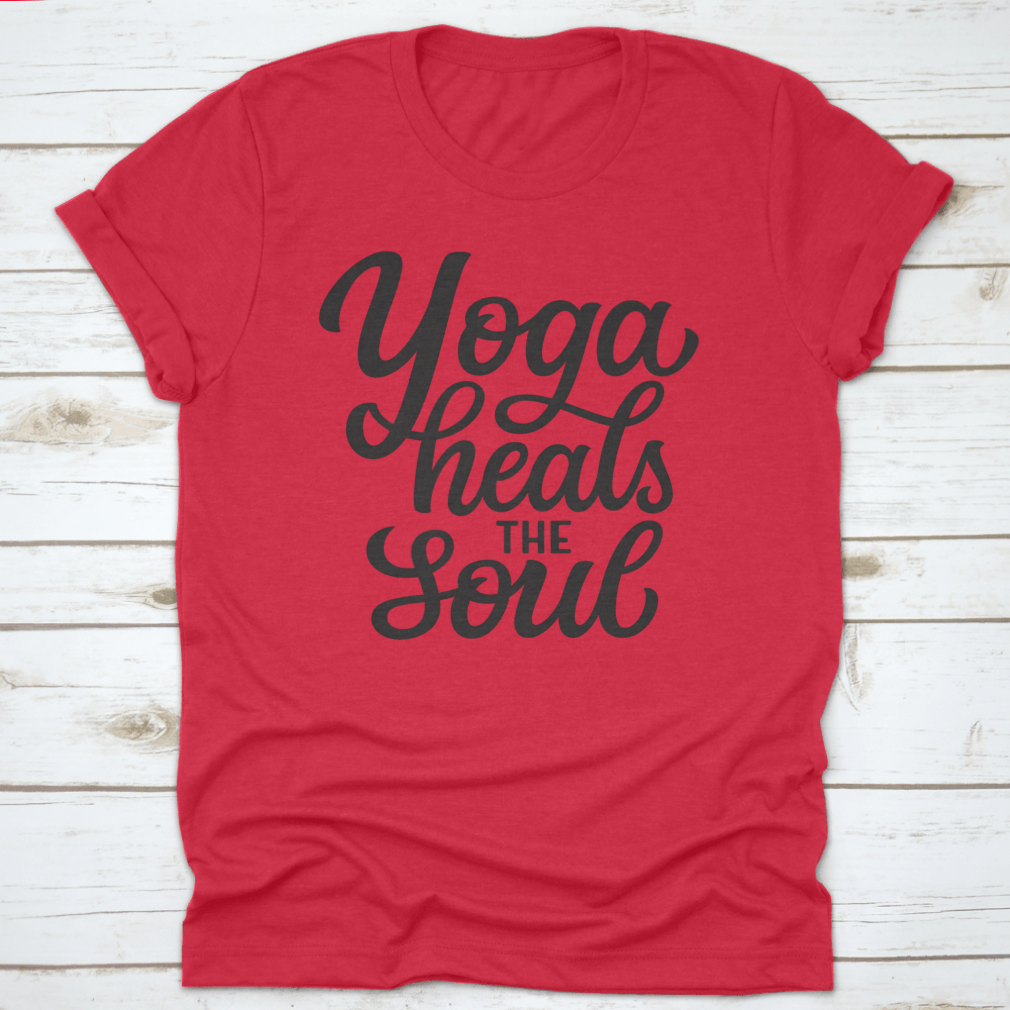 A hand-drawn quote 'Yoga Heals The Soul' printed on a white cotton t-shirt, showcasing a stylish and inspirational design.
