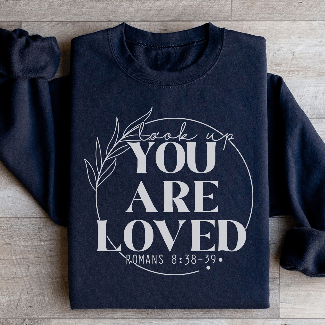 Cozy 'You Are Loved' sweats featuring a cotton/poly fleece blend, designed by top artists, showcasing vibrant colors and adjustable cuffs.
