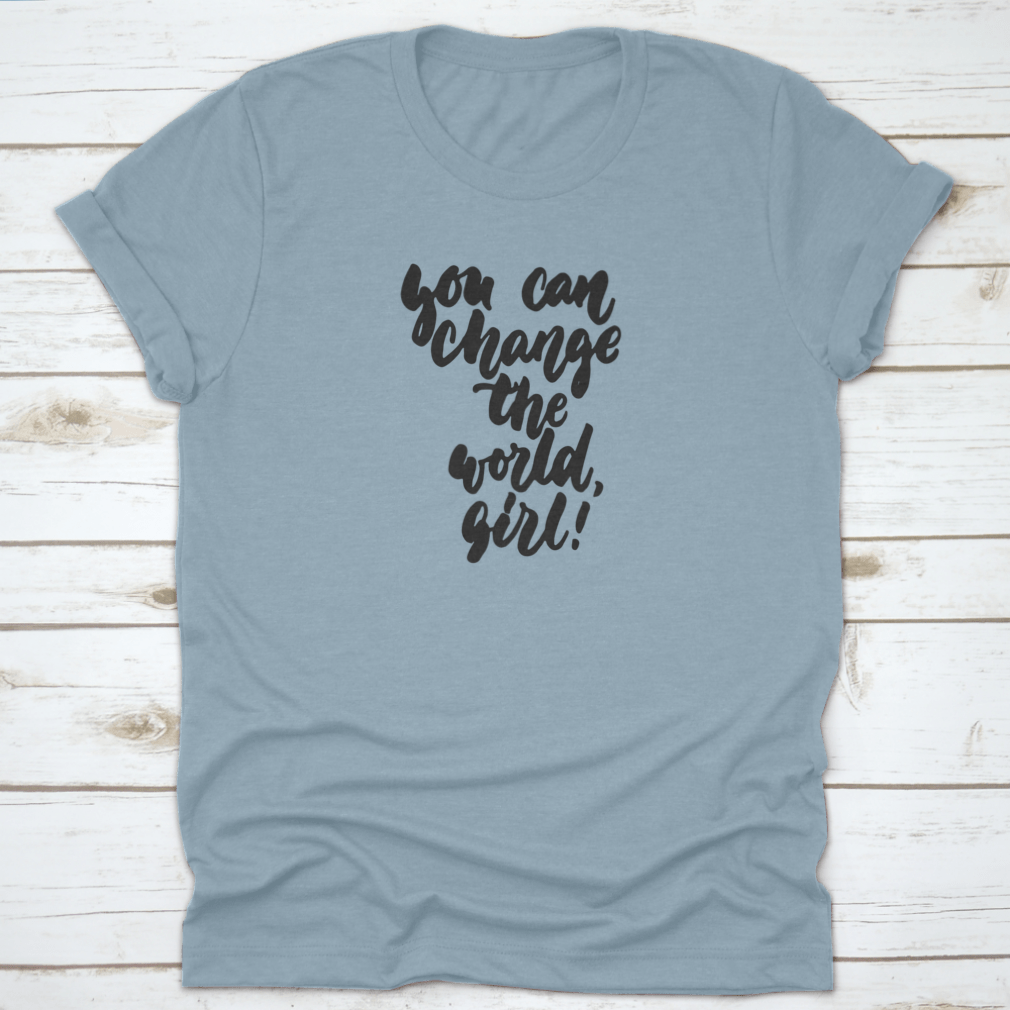 A stylish t-shirt featuring hand-drawn lettering that reads 'You Can Change The World, Girl', made from soft cotton fabric.