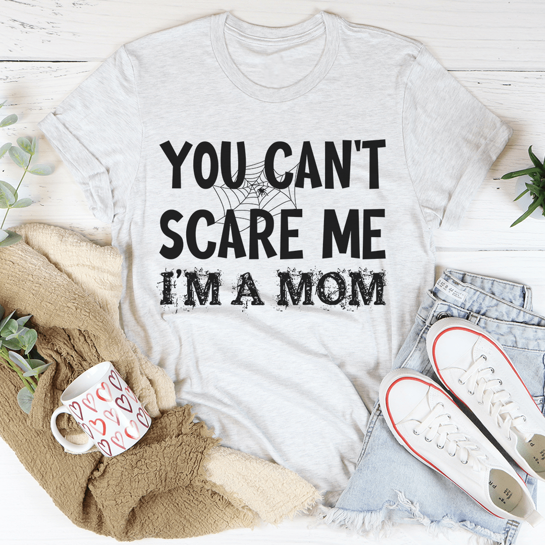 A black Halloween tee featuring the phrase 'You Can't Scare Me I'm A Mom' in bold white letters, made from 100% soft cotton.