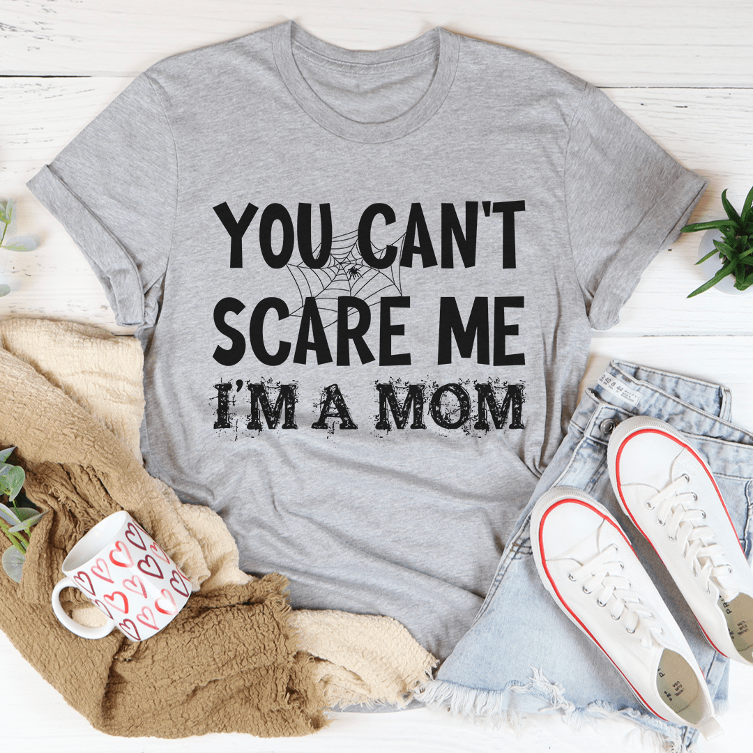 A black Halloween tee featuring the phrase 'You Can't Scare Me I'm A Mom' in bold white letters, made from 100% soft cotton.