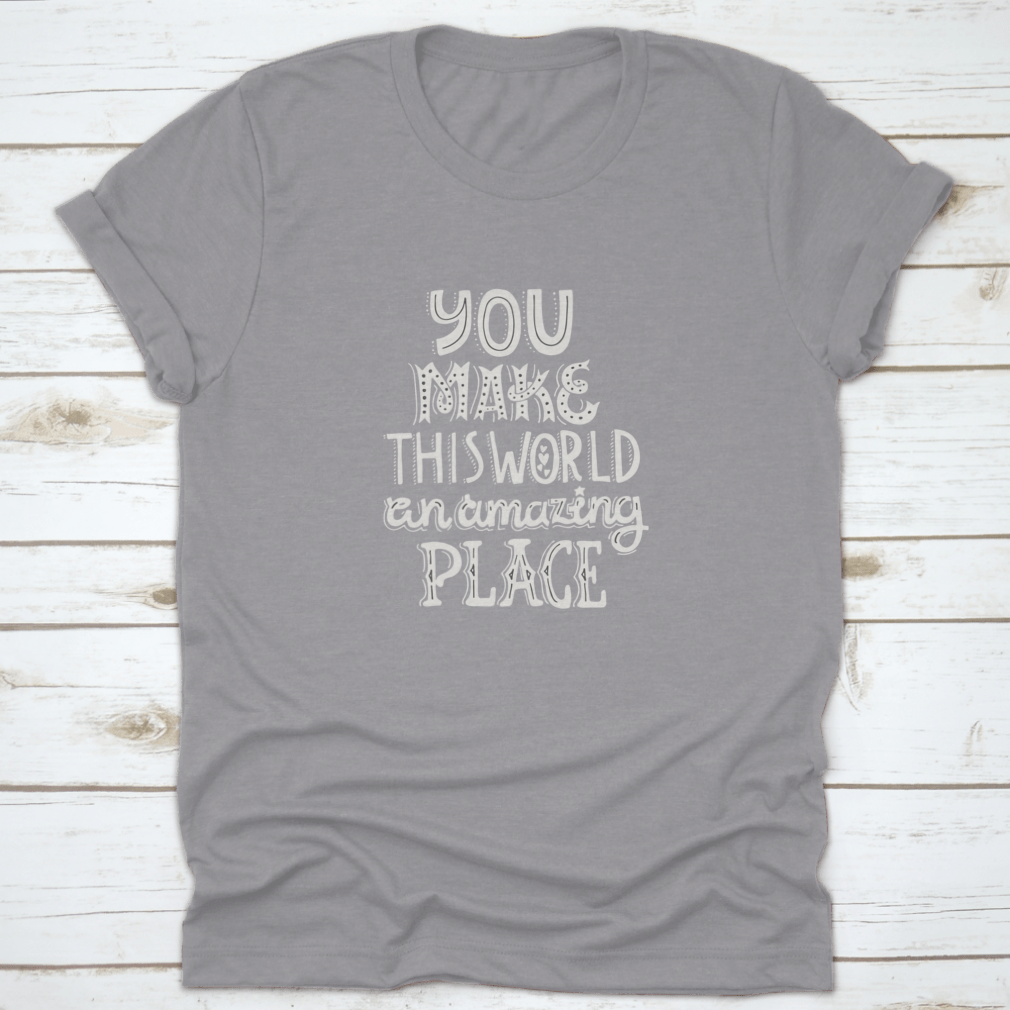 A stylish t-shirt featuring unique hand-drawn lettering that reads 'You Make This World An Amazing Place', showcasing its comfortable fabric and classic fit.