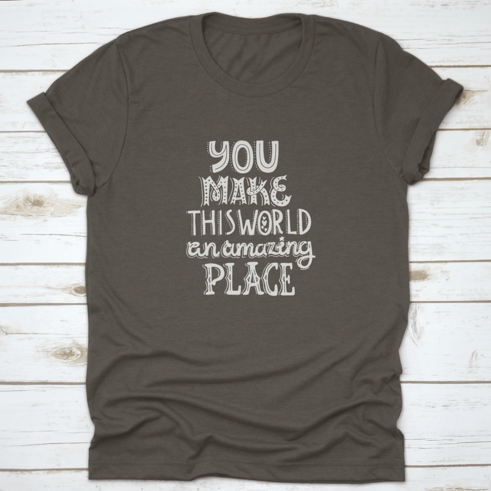 A stylish t-shirt featuring unique hand-drawn lettering that reads 'You Make This World An Amazing Place', showcasing its comfortable fabric and classic fit.