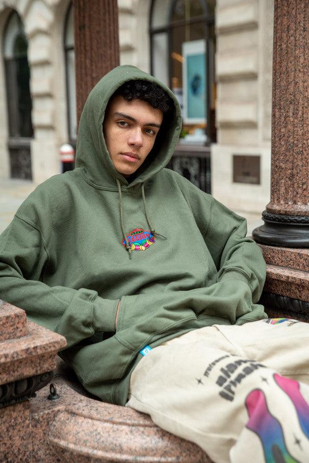 A stylish green hoodie featuring Dream Casino embroidery on the front, showcasing a relaxed fit and label detailing on the hem.
