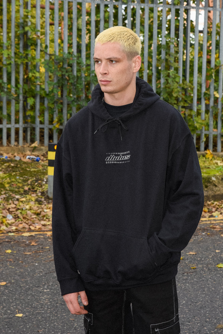 Black unisex hoodie featuring DBDNS futuristic logo embroidery, showcasing a relaxed fit and heavyweight cotton material.