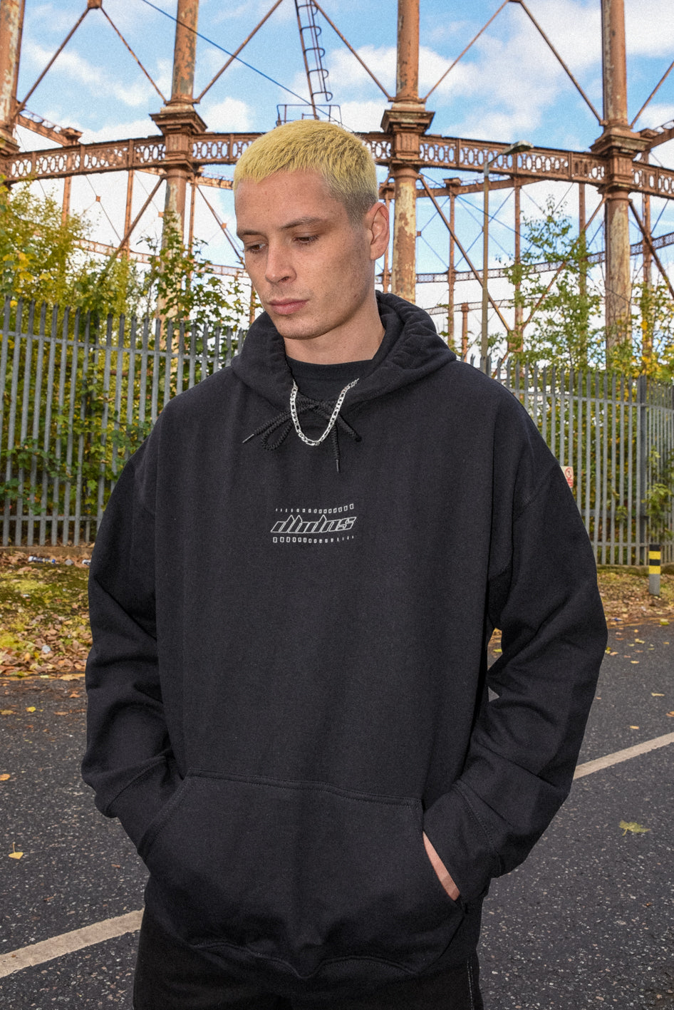 Black unisex hoodie featuring DBDNS futuristic logo embroidery, showcasing a relaxed fit and heavyweight cotton material.