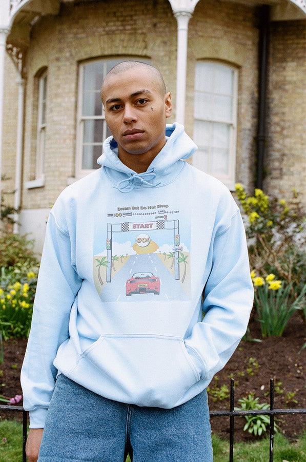 Light blue unisex hoodie featuring a retro Drive In To The Sunset print, perfect for casual wear.