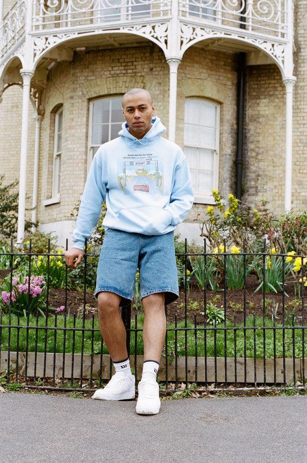 Light blue unisex hoodie featuring a retro Drive In To The Sunset print, perfect for casual wear.