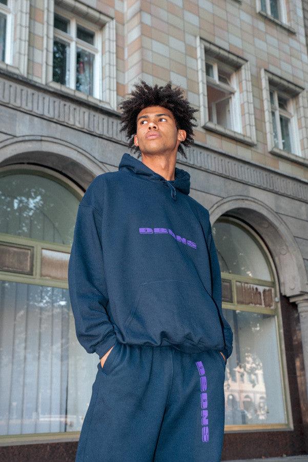 Navy joggers with purple embroidered logo, showcasing a relaxed fit and soft fabric, ideal for summer lounging.