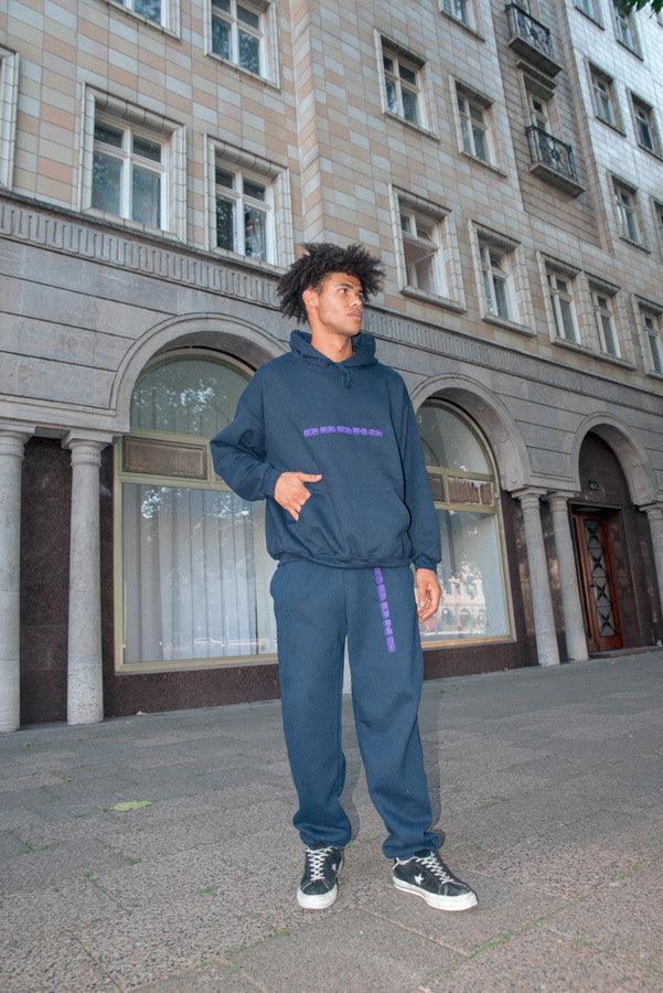 Navy joggers with purple embroidered logo, showcasing a relaxed fit and soft fabric, ideal for summer lounging.