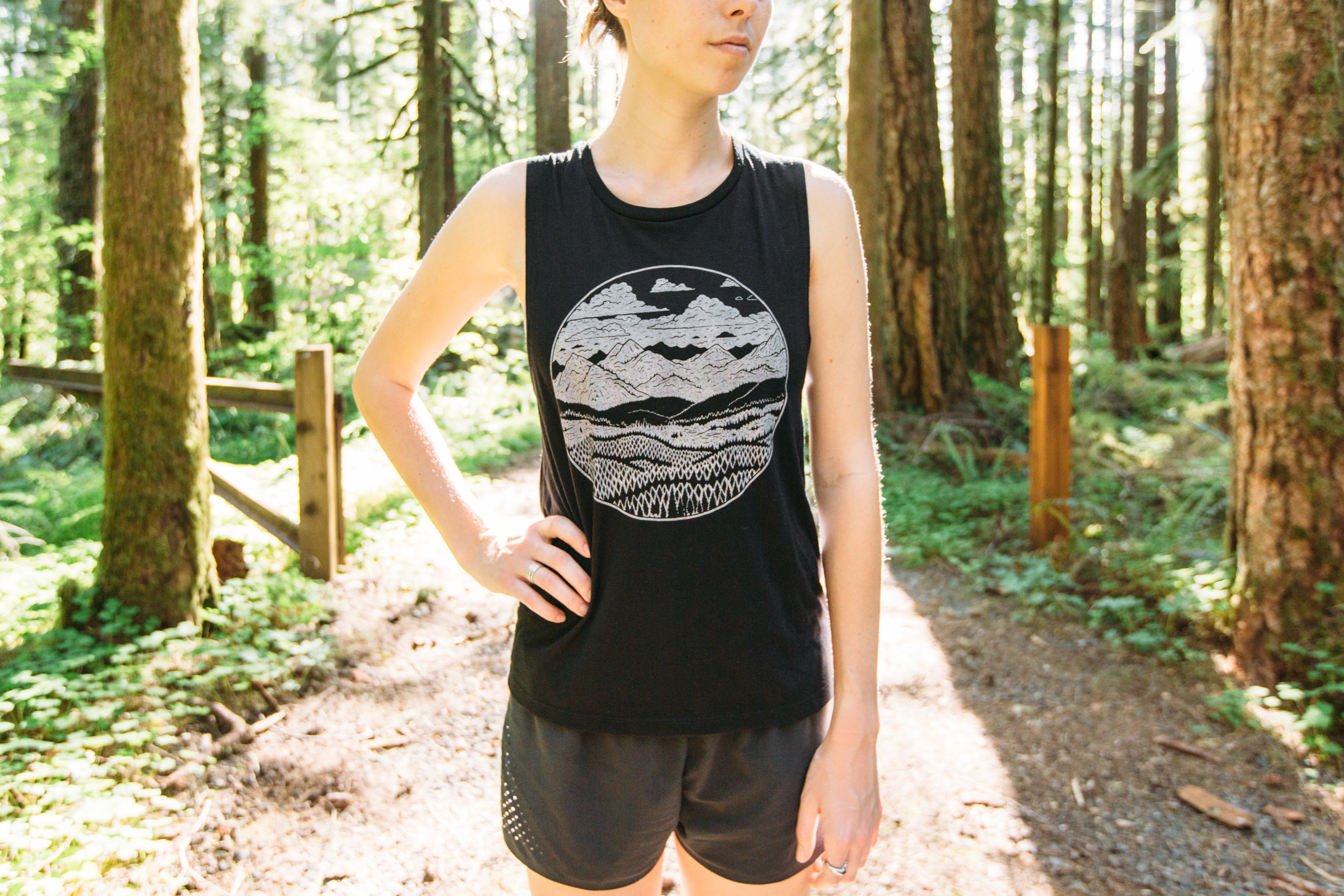Ladies Mountain Range Muscle Tank in black featuring a mountain range design, made from soft ringspun cotton.