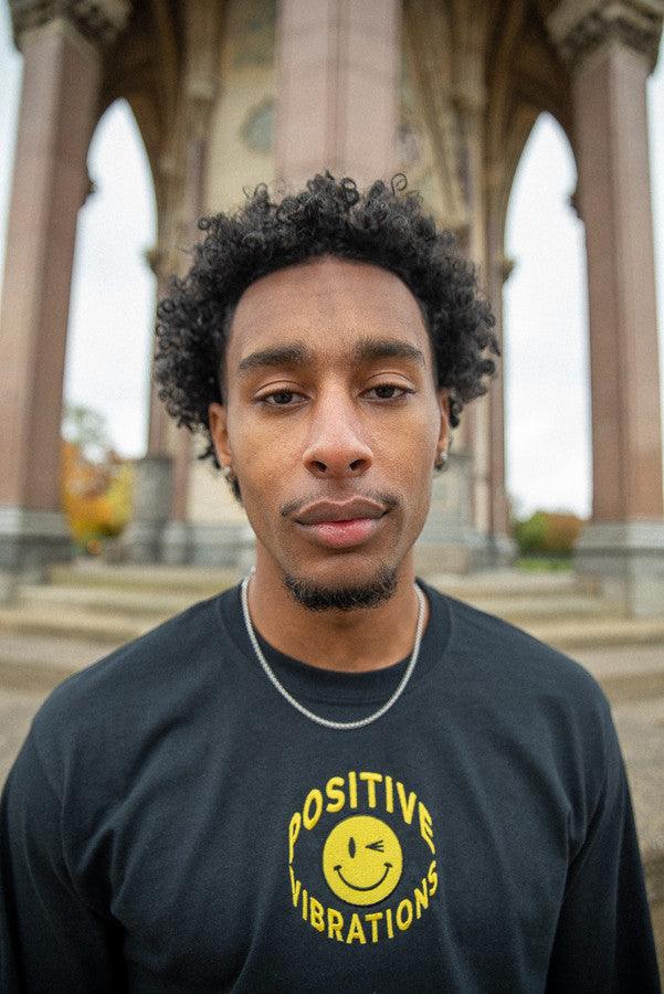 Black long sleeved t-shirt featuring vibrant 90s rave smiley embroidery, made from heavyweight cotton for comfort.
