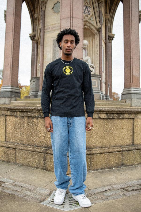 Black long sleeved t-shirt featuring vibrant 90s rave smiley embroidery, made from heavyweight cotton for comfort.