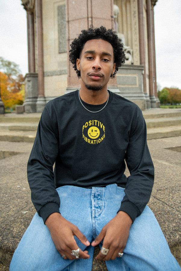 Black long sleeved t-shirt featuring vibrant 90s rave smiley embroidery, made from heavyweight cotton for comfort.
