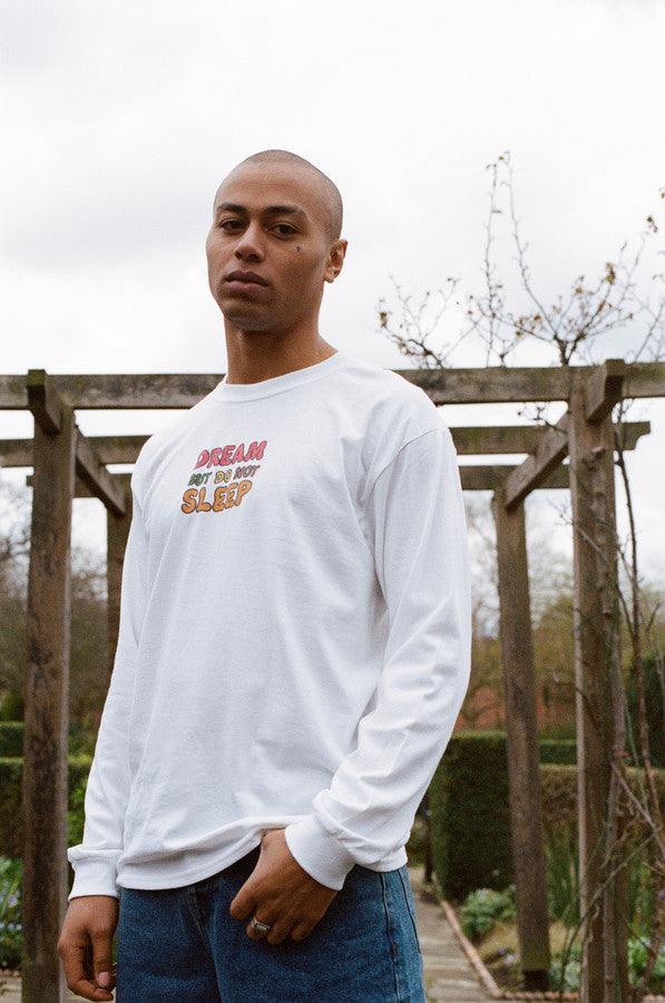 Long sleeved white t-shirt featuring colorful fruity ravers print with characters like watermelon, banana, and strawberry, perfect for festivals.