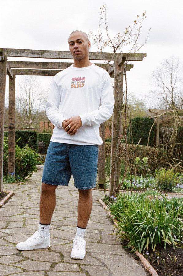 Long sleeved white t-shirt featuring colorful fruity ravers print with characters like watermelon, banana, and strawberry, perfect for festivals.