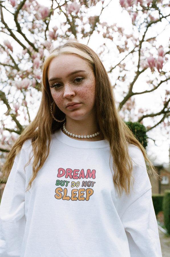 Long sleeved white t-shirt featuring colorful fruity ravers print with characters like watermelon, banana, and strawberry, perfect for festivals.