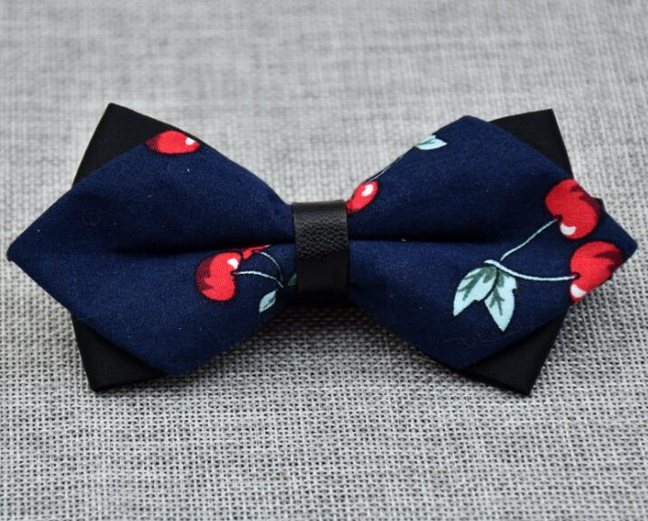 Men's navy blue pre-tied bow tie with red cherries pattern, made from 100% cotton, elegantly displayed in protective packaging.