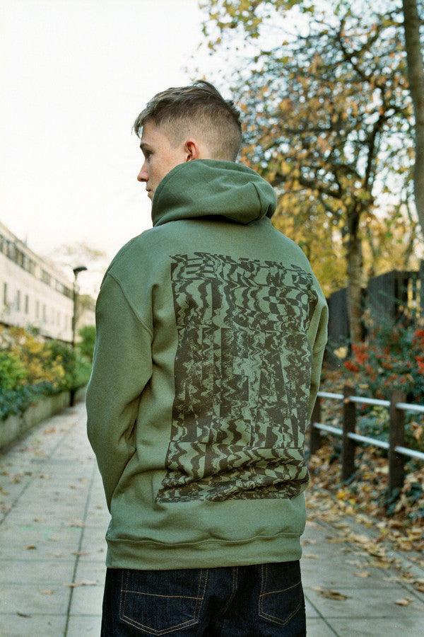 Military green hoodie featuring 'The End Is Near' printed design on the front, showcasing a relaxed fit and woven label details.